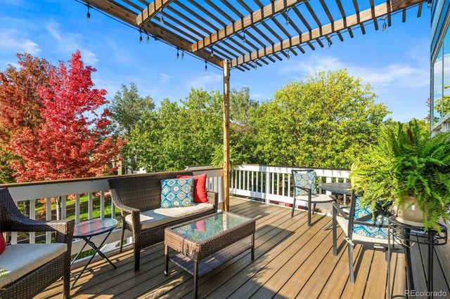 a balcony with wooden floor and outdoor seating