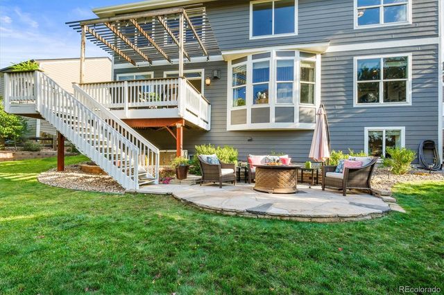 a view of a house with backyard sitting area and garden