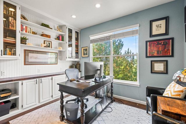 a view of a workspace with furniture and a window