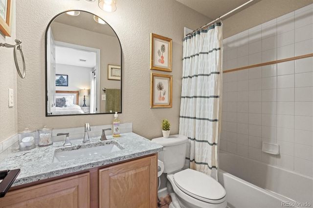 a bathroom with a granite countertop toilet sink and mirror
