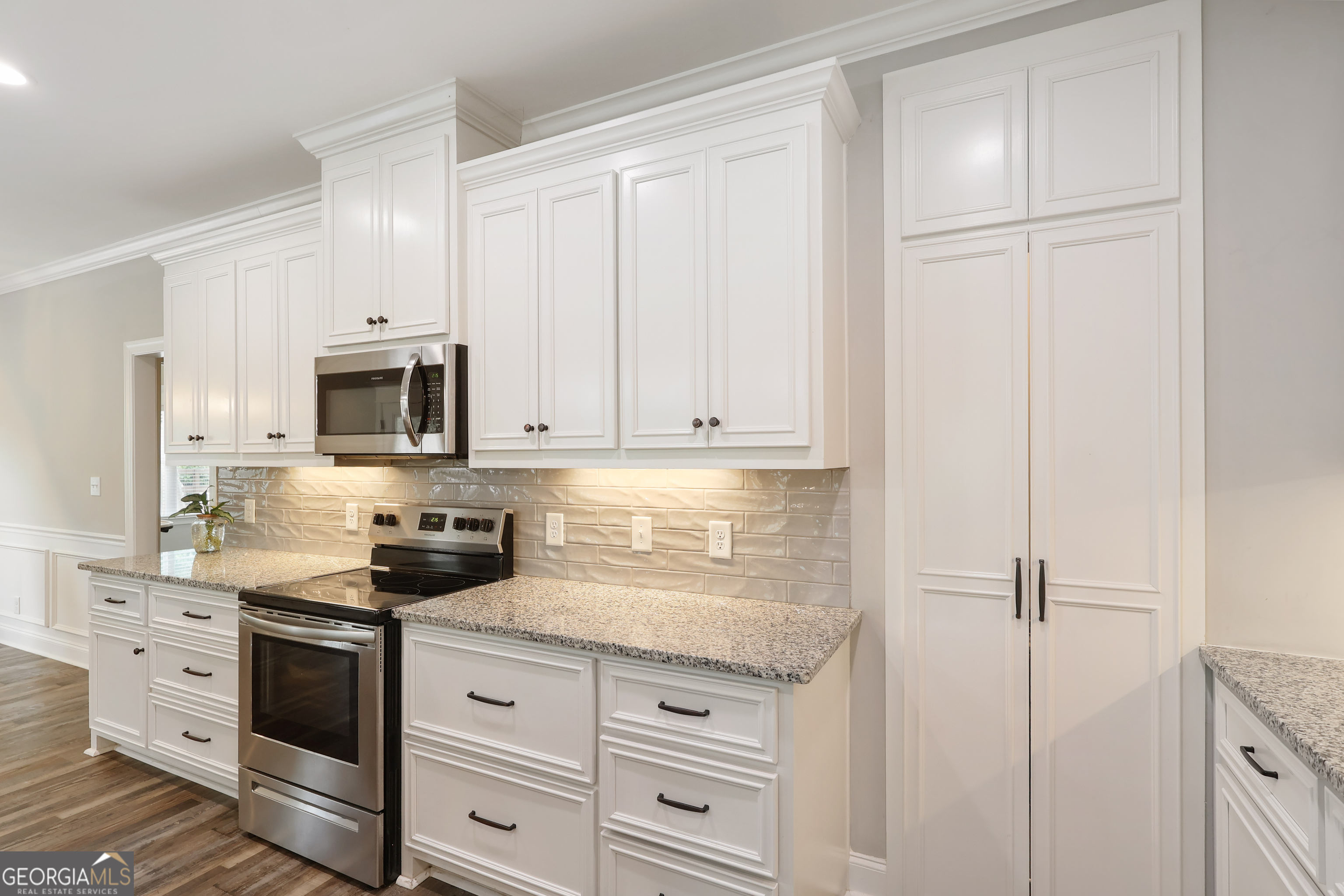 89 Claire Road Forsyth, GA 31029 - Photo 19 of 40 a kitchen with white cabinets and black appliances