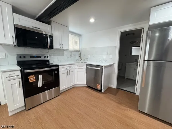 a kitchen with stainless steel appliances granite countertop a stove top oven a refrigerator a sink and dishwasher