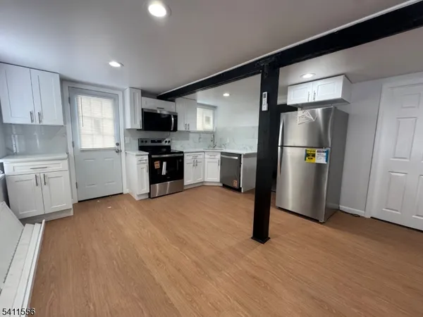 a kitchen with stainless steel appliances granite countertop a refrigerator and a stove top oven