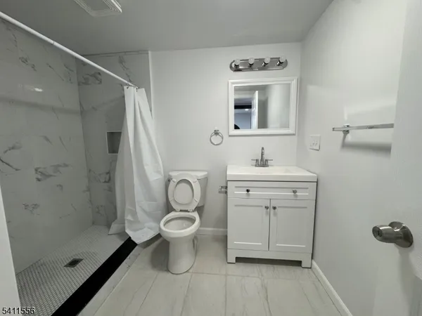 a bathroom with a sink toilet a mirror and shower