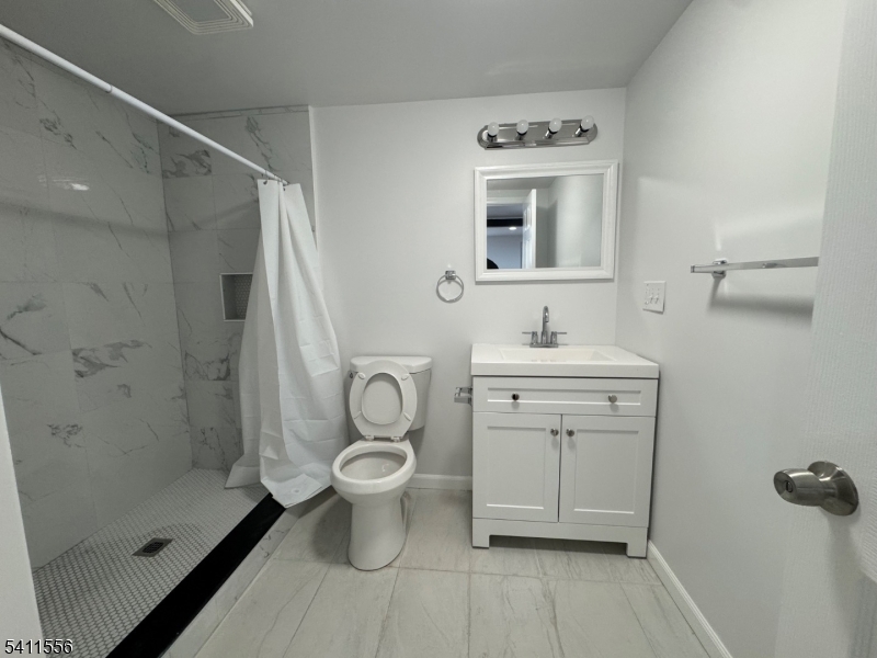 233 Franklin Road Denville, NJ 07834 - Photo 7 of 8 a bathroom with a sink toilet a mirror and shower