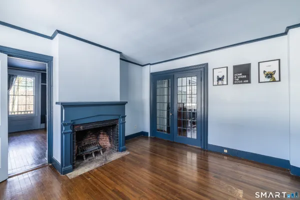 a view of a livingroom with wooden floor and a fireplace