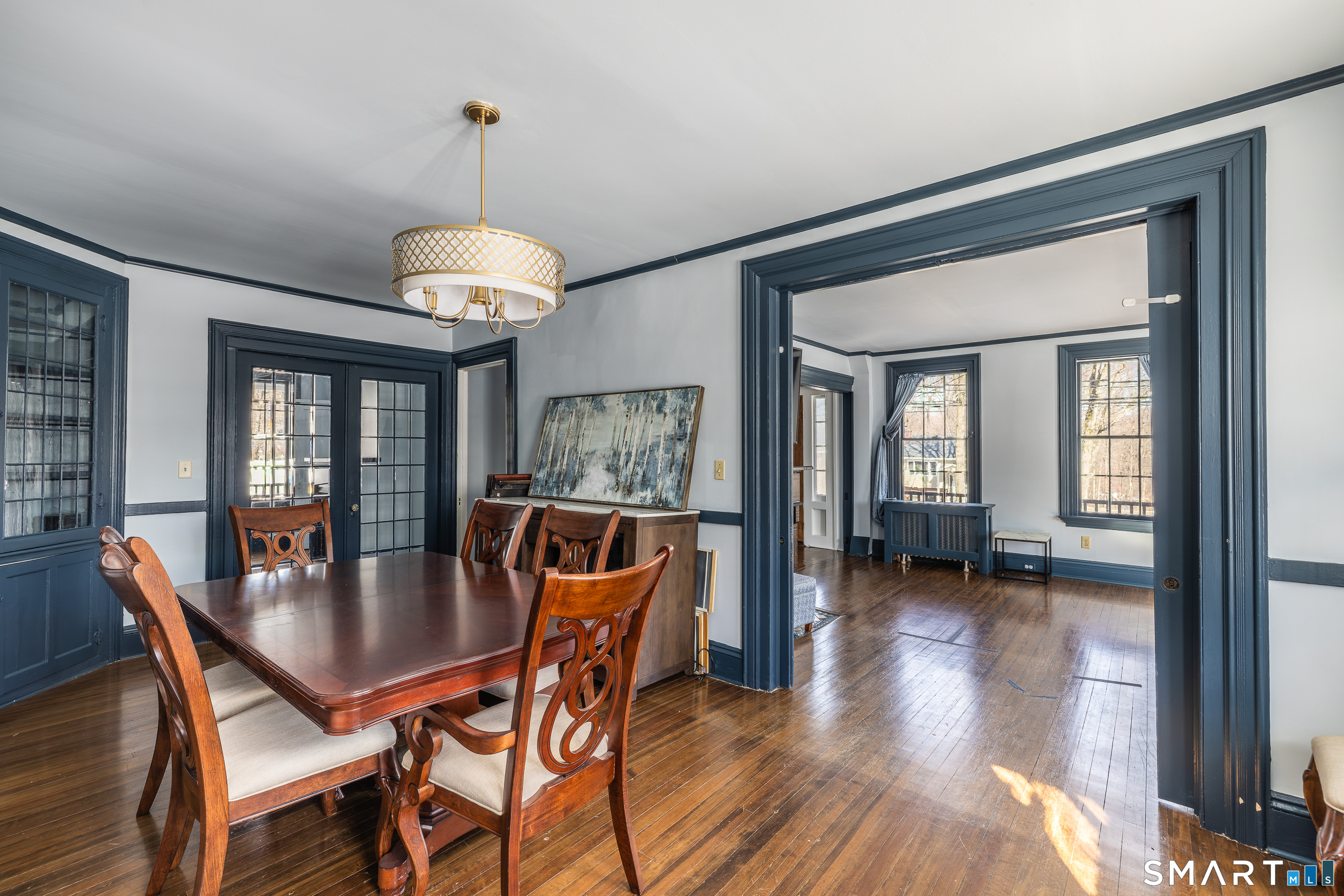 5385 Main Street Trumbull, CT 06611 - Photo 9 of 39 a dining room with wooden floor a chandelier a wooden table and chairs
