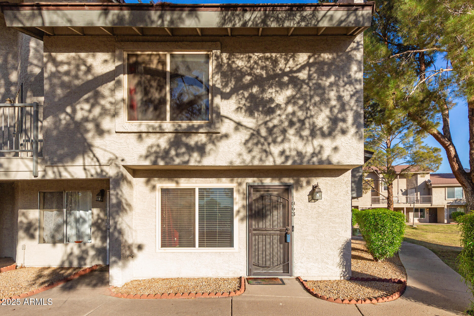 a front view of a house with a tree