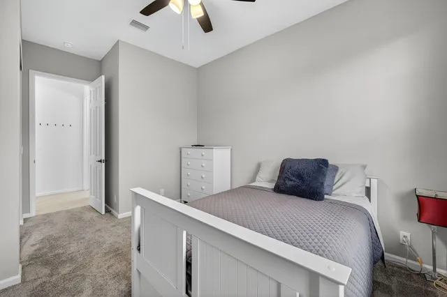 a bedroom with a bed and a ceiling fan