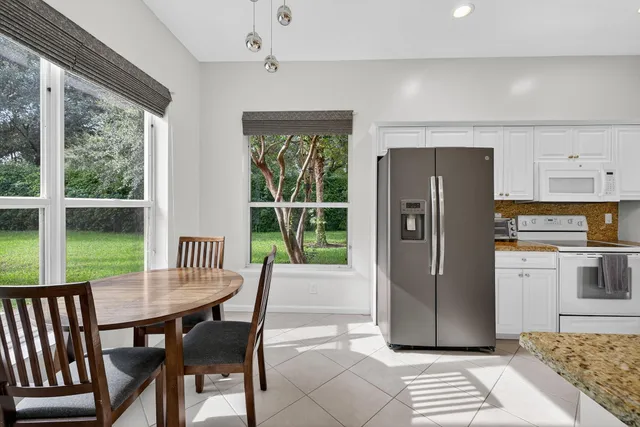 a view of a dining room with furniture large window and refrigerator