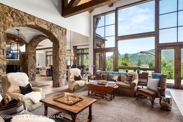 a living room with furniture fireplace and large windows