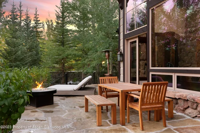 a view of a wooden chairs and table in the patio