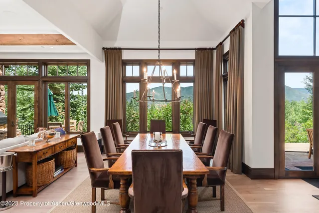 a kitchen with stainless steel appliances kitchen island granite countertop a table chairs sink and cabinets