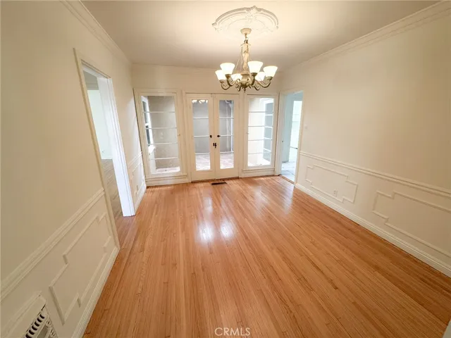a view of a big room with wooden floor and chandelier