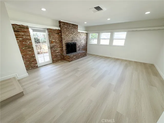 wooden floor in an empty room with a fireplace