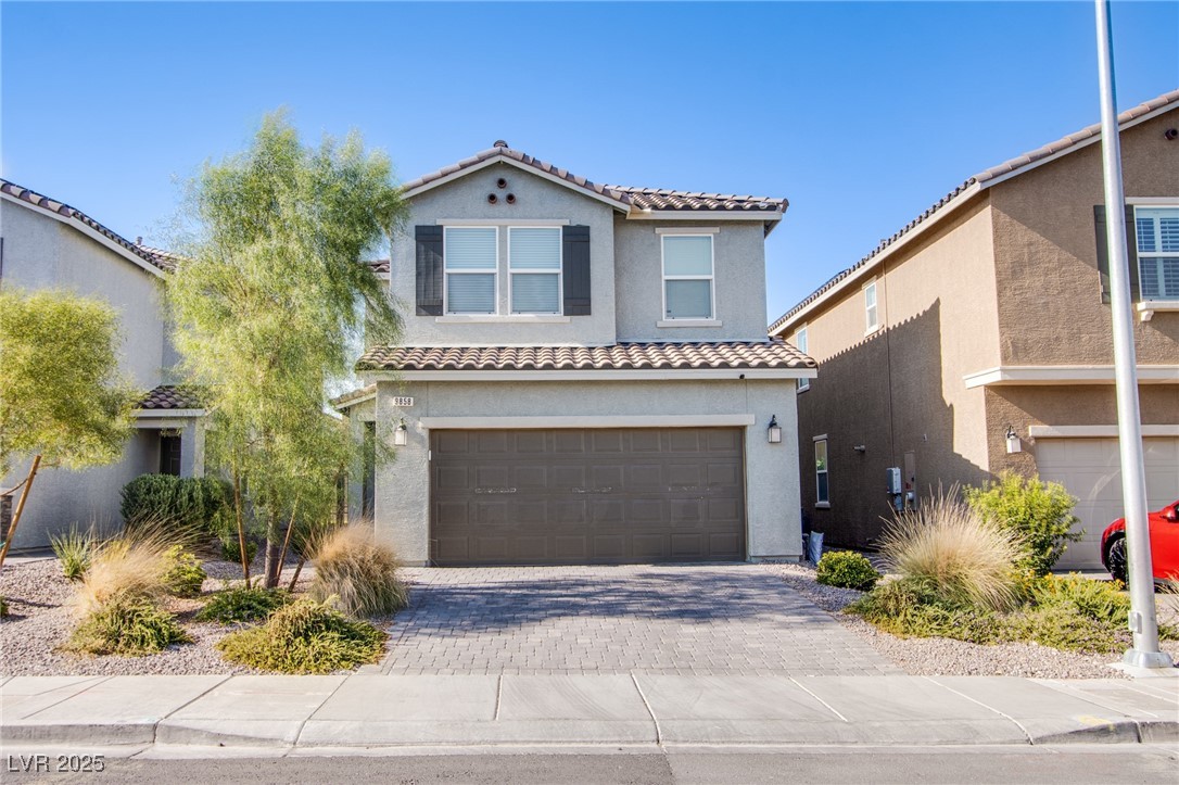 Mediterranean / spanish-style home featuring stucco siding, a tile roof, decorative driveway, and a garage