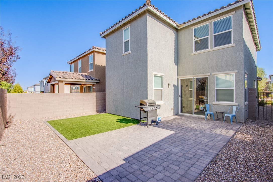 9858 West Meranto Avenue Las Vegas, NV 89178 - Photo 11 of 36 Rear view of house featuring a fenced backyard, a tiled roof, stucco siding, and a patio