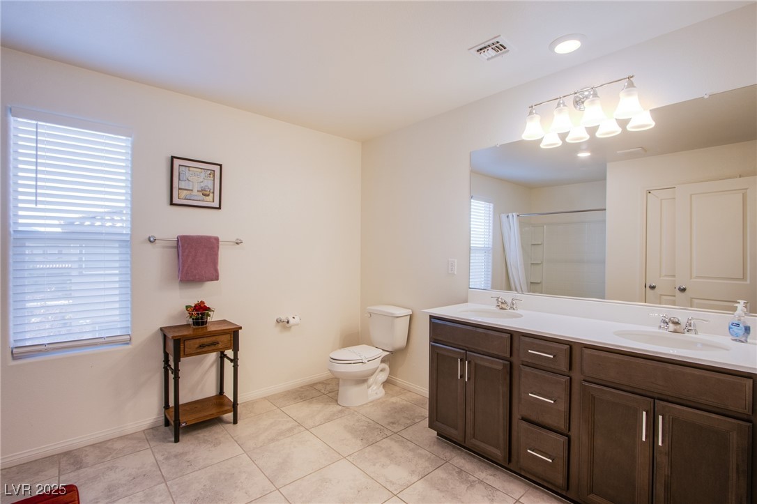 9858 West Meranto Avenue Las Vegas, NV 89178 - Photo 22 of 36 Full bath featuring double vanity, a shower with shower curtain, light tile patterned floors, and recessed lighting