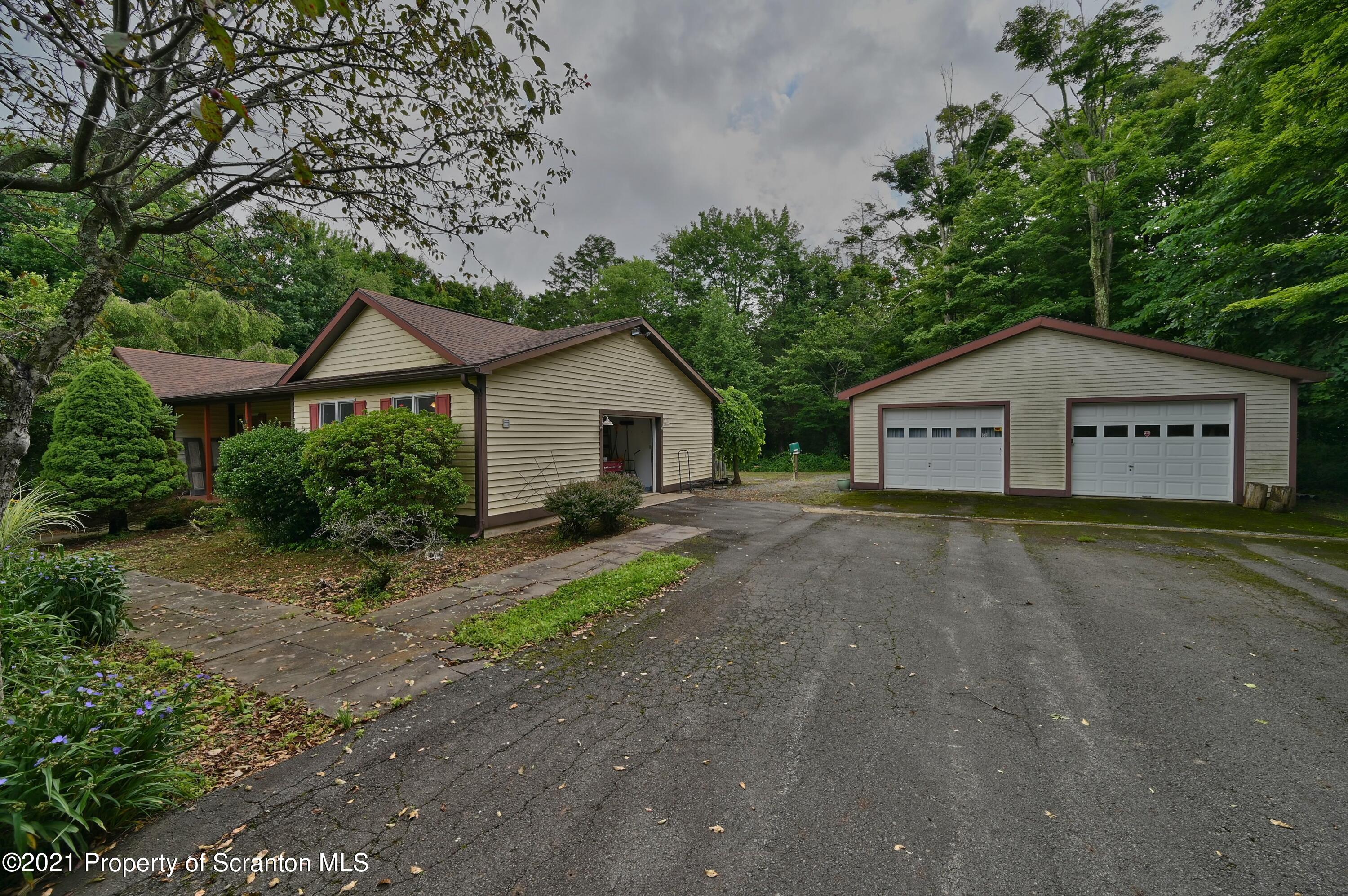 454 Twin Rocks Road Sterling, PA 18463 - Photo 64 of 102 a front view of a house with a yard and garage