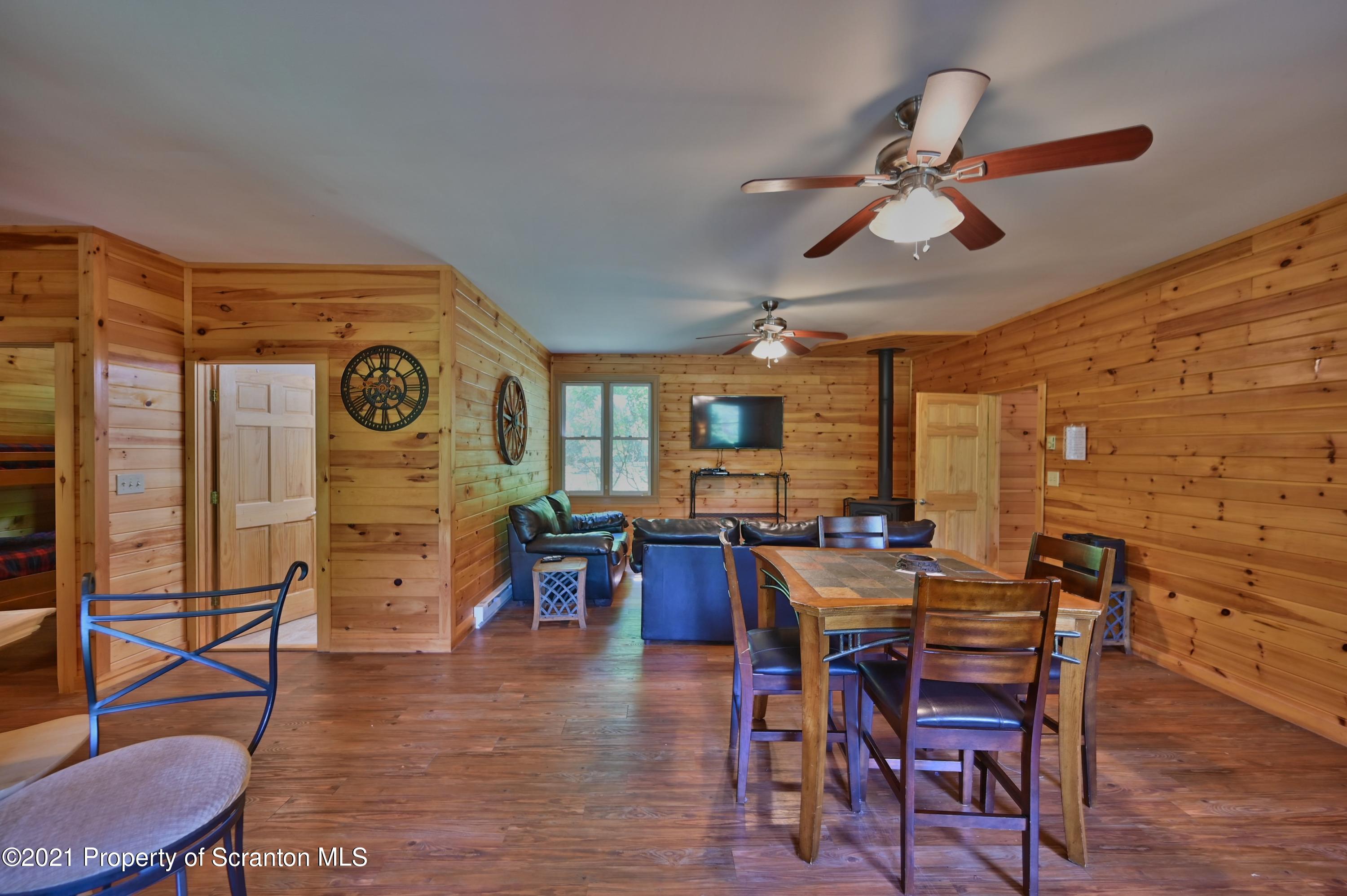 454 Twin Rocks Road Sterling, PA 18463 - Photo 69 of 102 a view of a livingroom with furniture and a dining table with wooden floor