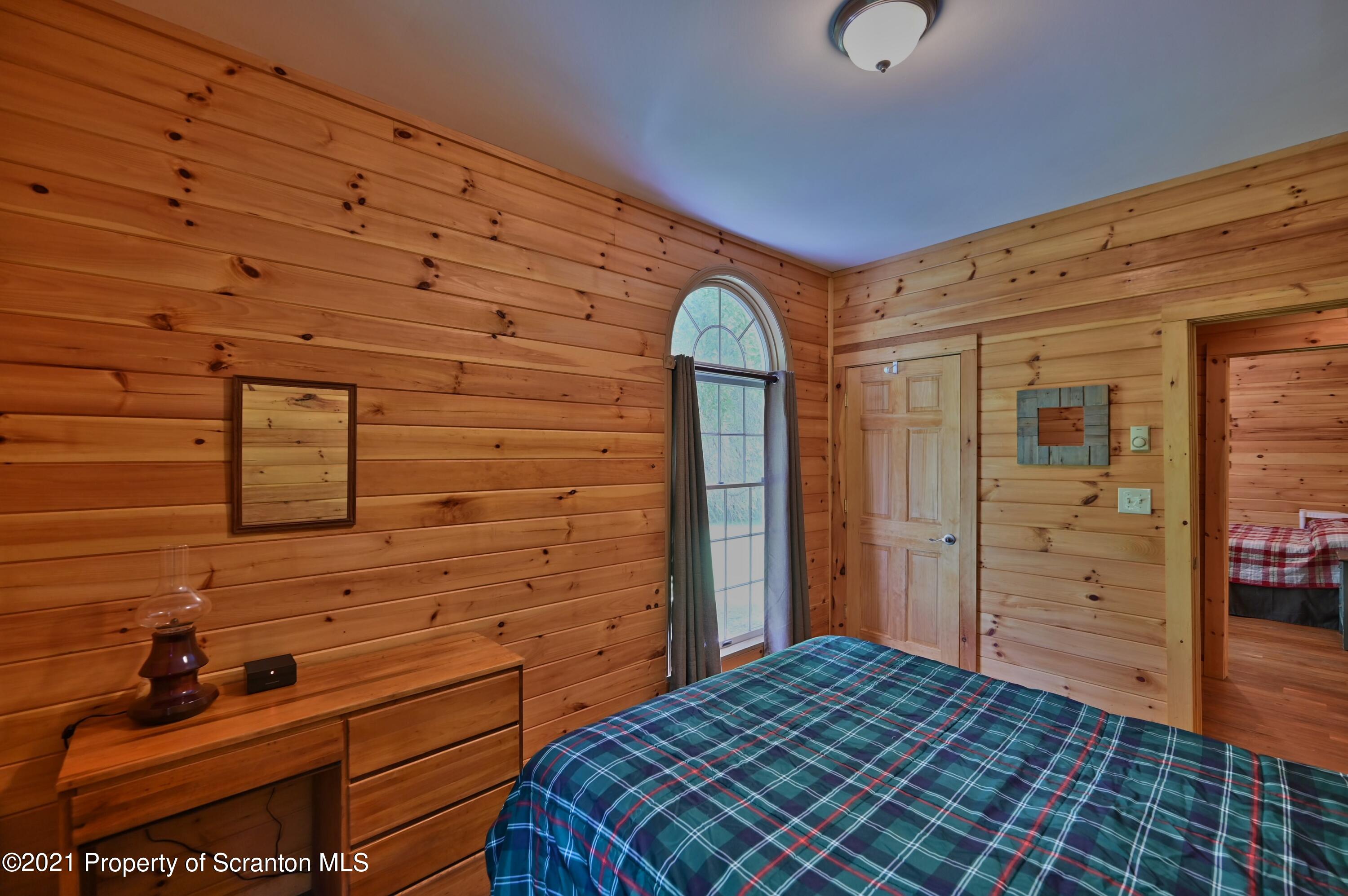 454 Twin Rocks Road Sterling, PA 18463 - Photo 87 of 102 a bedroom with a bed and wooden floor