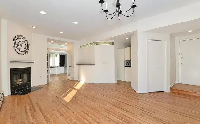 a view of empty room with wooden floor and fireplace