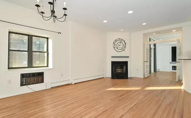 a view of a livingroom with a fireplace and window