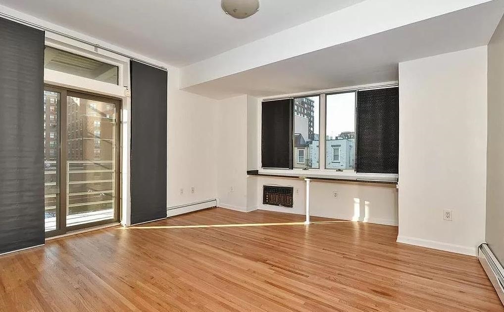 80 Bloomfield Street, Unit 4B Hoboken, NJ 07030 - Photo 8 of 11 a view of an empty room with wooden floor and a window