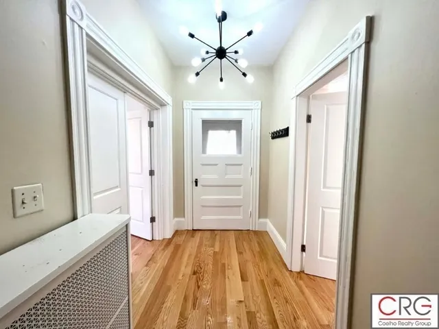a view of a hallway view with wooden floor and cabinet