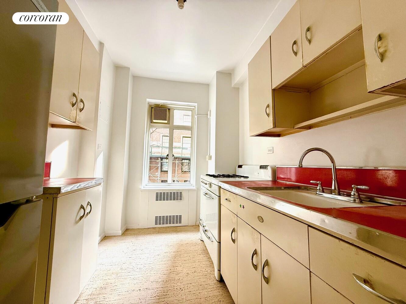 65 East 76th Street, Unit 2C Manhattan, NY 10021 - Photo 3 of 7 a kitchen with stainless steel appliances granite countertop a sink a stove and a refrigerator