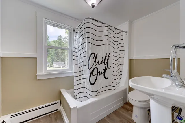 a bathroom with a sink a toilet and a window