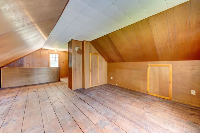 a view of a big room with wooden floor and windows