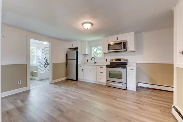 a kitchen with granite countertop a refrigerator and a stove top oven