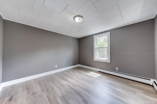 wooden floor in an empty room with a window