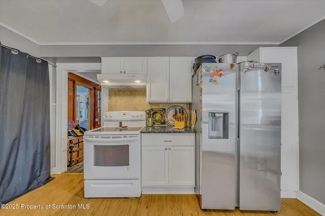 a kitchen with stainless steel appliances granite countertop a refrigerator and a stove