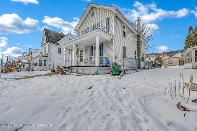 a view of a white house with a yard