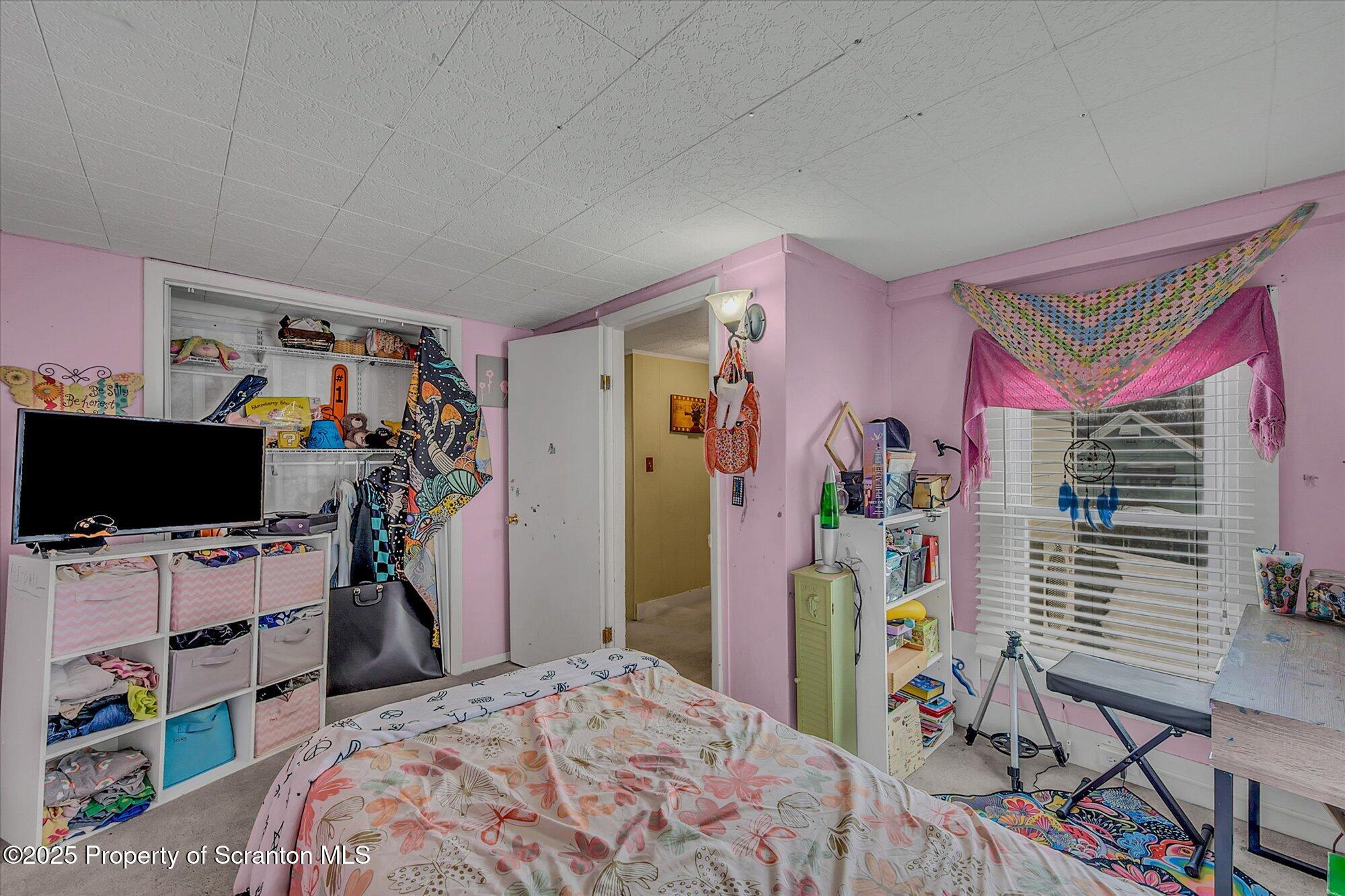 219 1st Street Olyphant, PA 18447 - Photo 34 of 43 a bedroom with a bed a flat screen tv and a desk