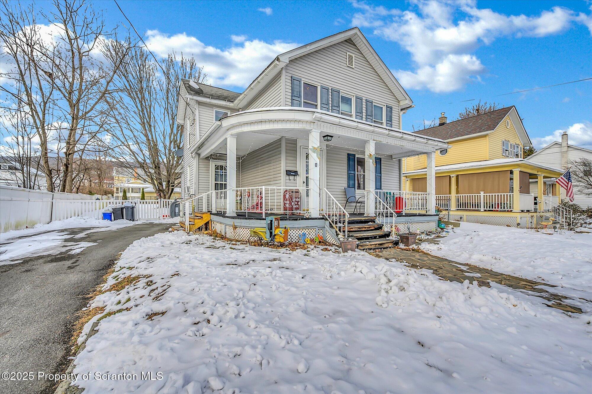 219 1st Street Olyphant, PA 18447 - Photo 4 of 43 a view of a white house with large windows next to a road