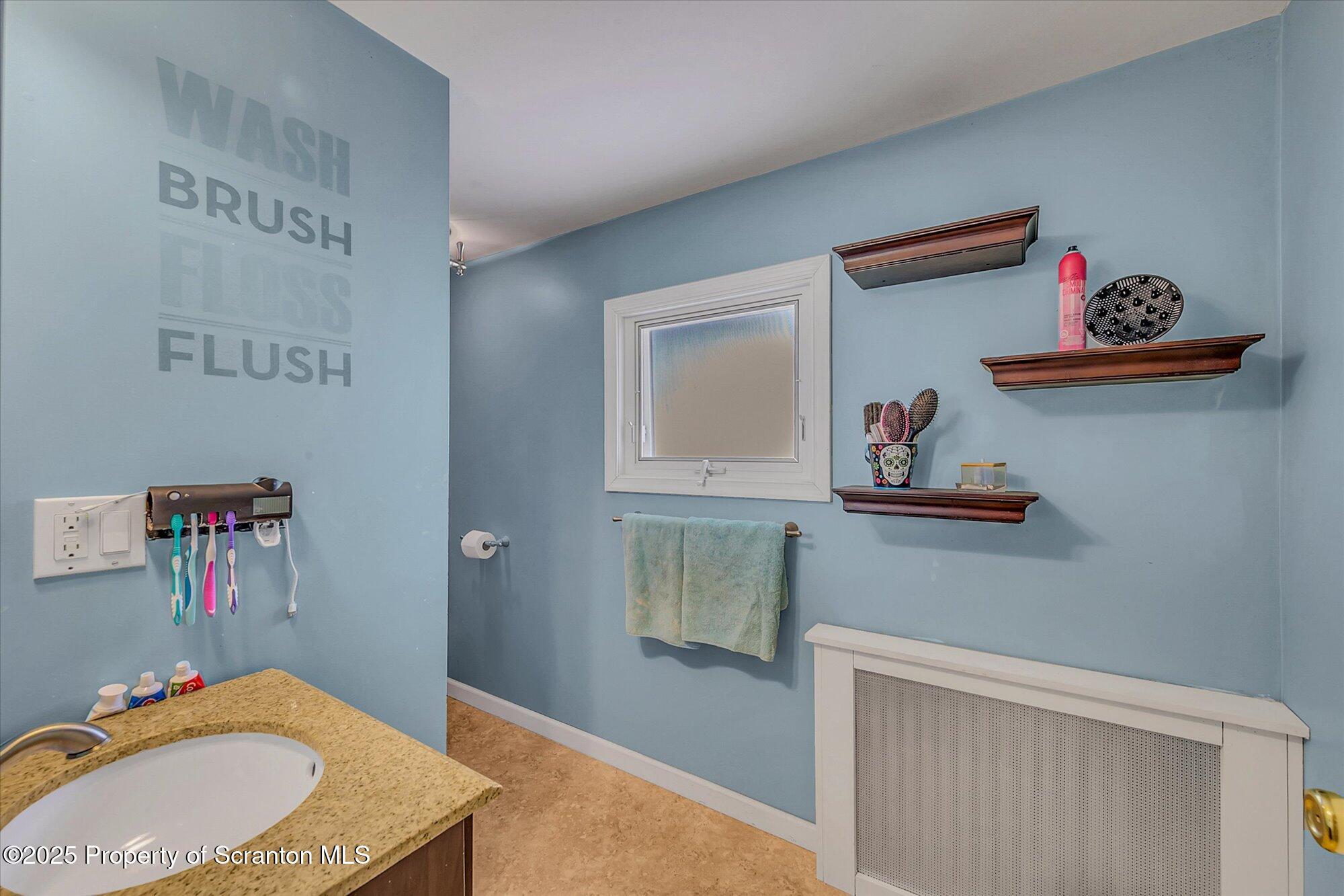 219 1st Street Olyphant, PA 18447 - Photo 41 of 43 a bathroom with a granite countertop sink and a mirror