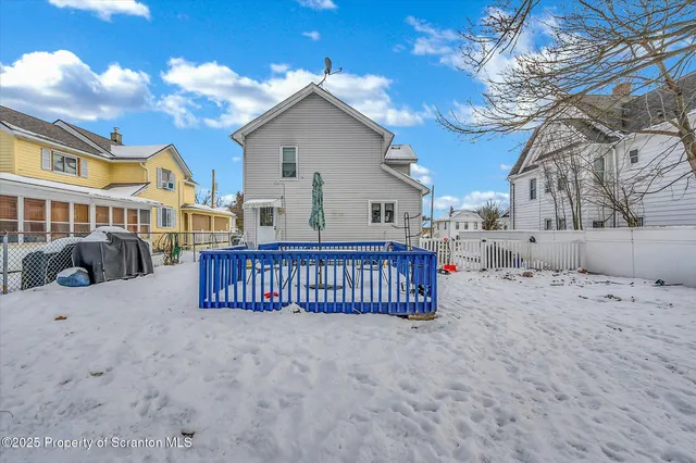 a view of a house with a yard covered in snow