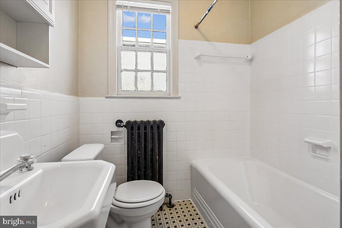 3944 7th Street Northeast, Unit 4 Washington, DC 20017 - Photo 12 of 19 a white toilet sitting next to a bath tub