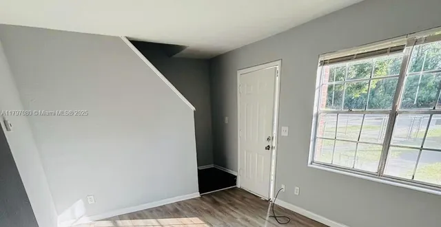 a view of bedroom with wooden floor and window