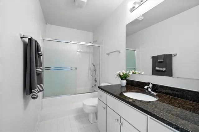 a bathroom with a granite countertop sink toilet and shower