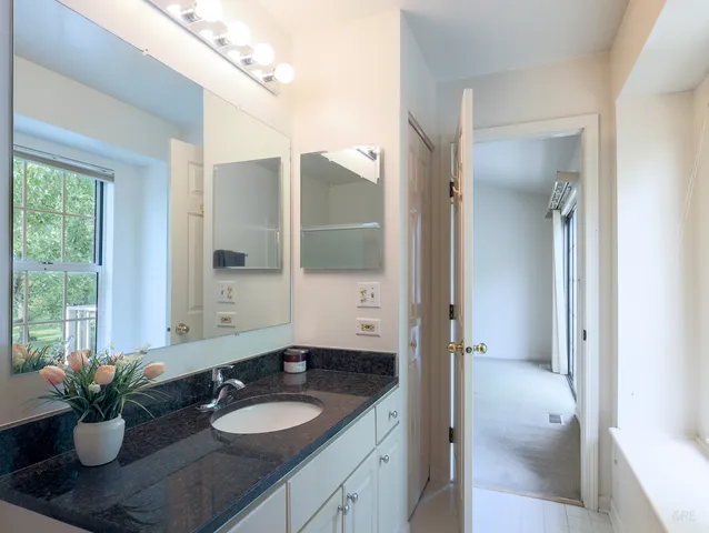 a bathroom with a granite countertop sink a large mirror and a shower