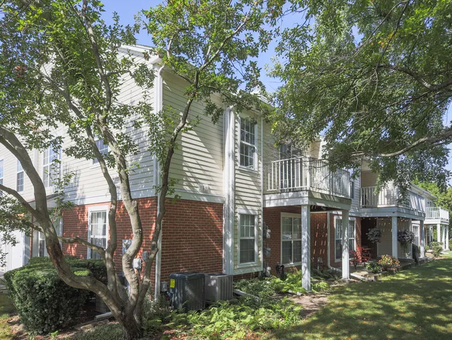 a view of a house with a tree next to a yard