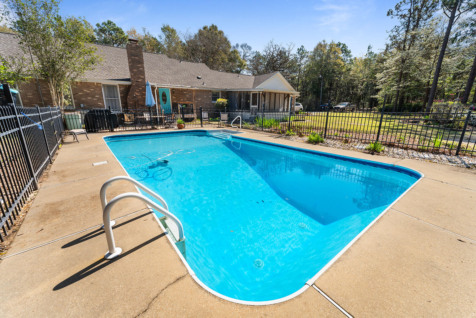 3687 Airport Road Crestview, FL 32539 - Photo 69 of 74 a view of swimming pool with outdoor seating and trees in the background