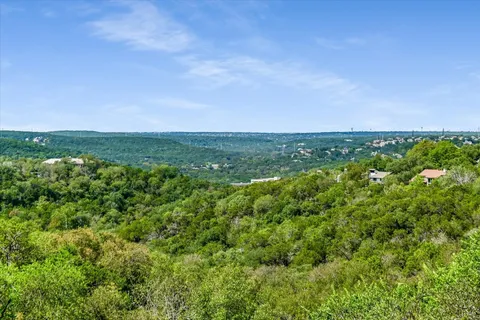 an aerial view of residential houses with outdoor space and trees