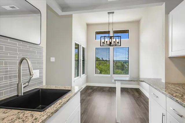 a kitchen with granite countertop a stove a sink and a window