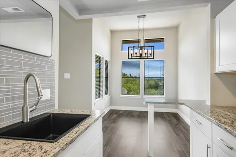 a kitchen with granite countertop a stove a sink and a window