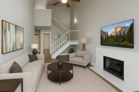 a living room with furniture a flat screen tv and a fireplace